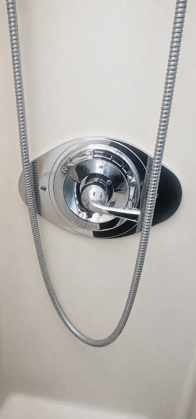 Chrome Delta shower control and handle installed on shower wall