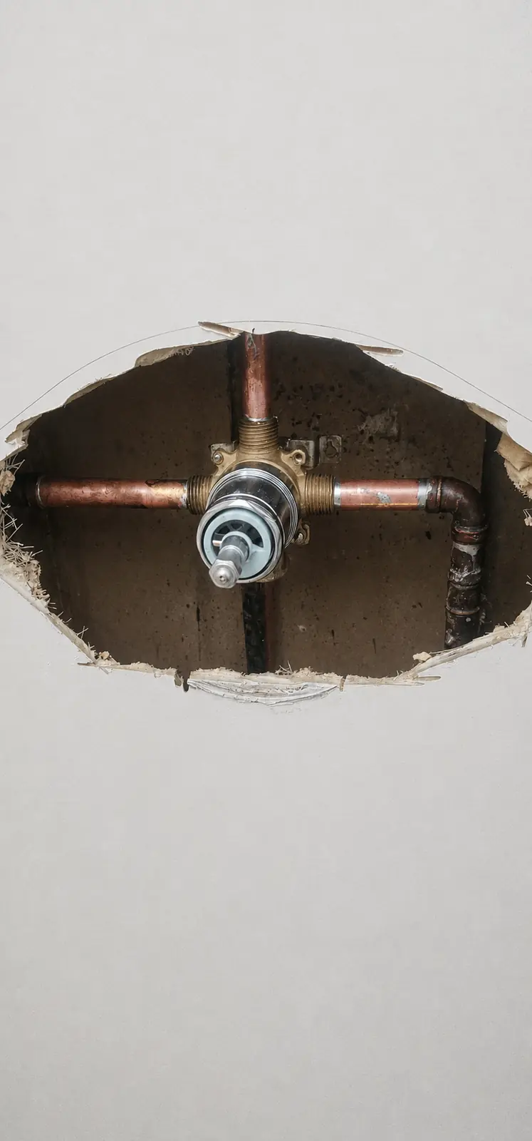 Exposed shower valve and copper piping during repair