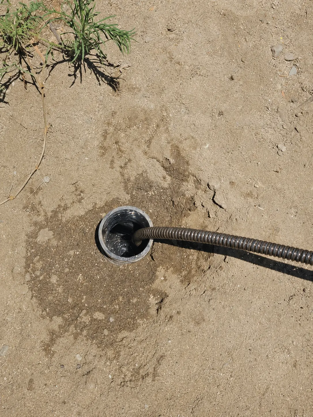 Drain cleaning cable entering an outdoor cleanout